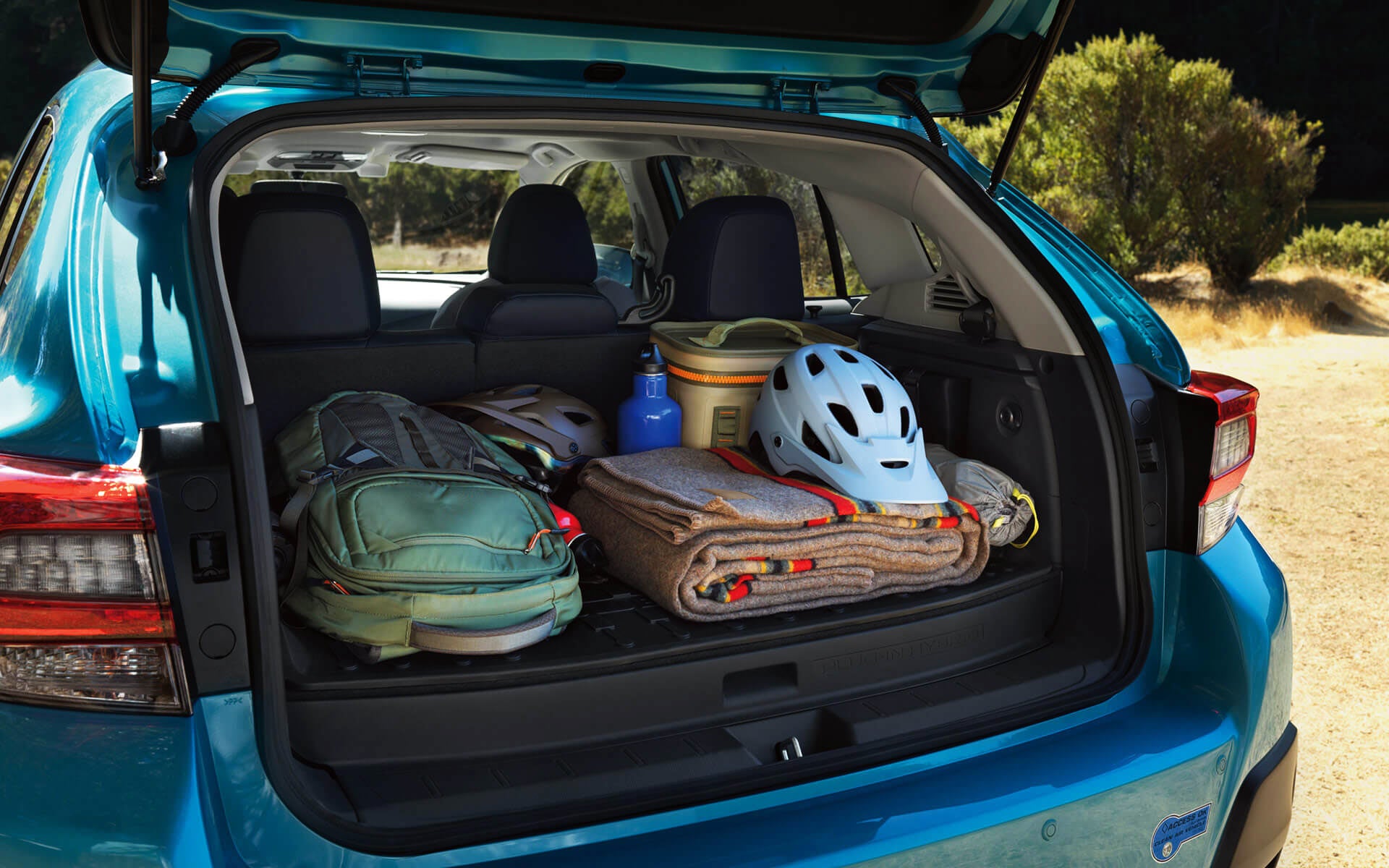 A backpack, blanket, and bike helmet in the rear cargo area of a Crosstrek Hybrid | Briggs Subaru of Topeka in Topeka KS
