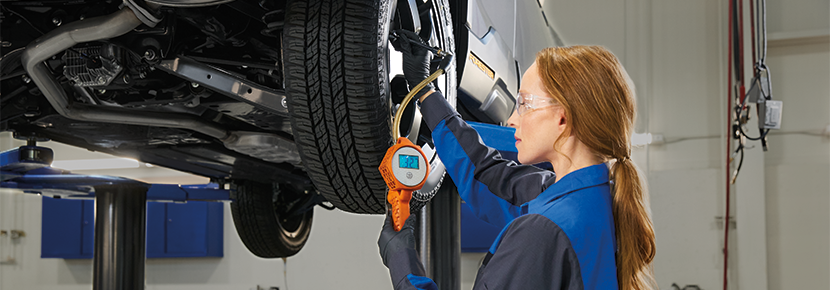 A Subaru technician checking tire pressure. | Briggs Subaru of Topeka in Topeka KS
