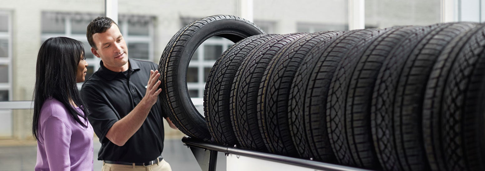 Subaru service representative showing customer a tire. | Briggs Subaru of Topeka in Topeka KS