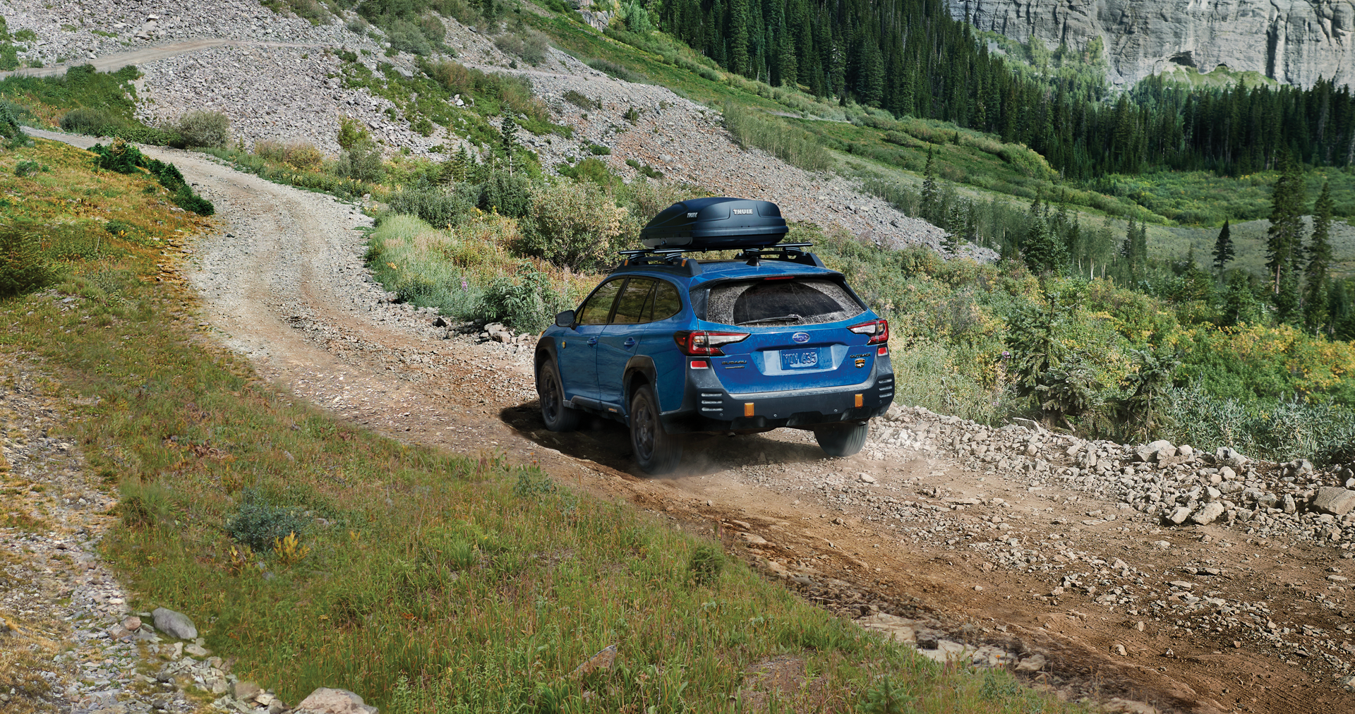 A 2023 Outback Wilderness driving on a trail in the mountains. | Briggs Subaru of Topeka in Topeka KS