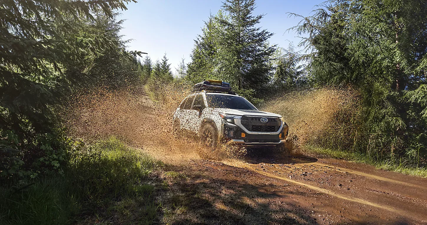 A Subaru Forester Wilderness on a muddy forest road.
