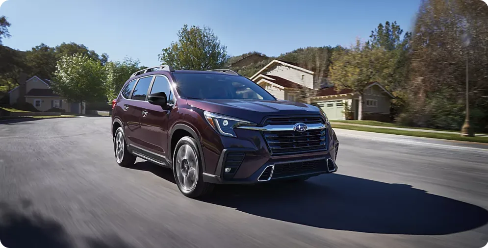 Dark red 2026 Subaru Ascent driving a suburban street