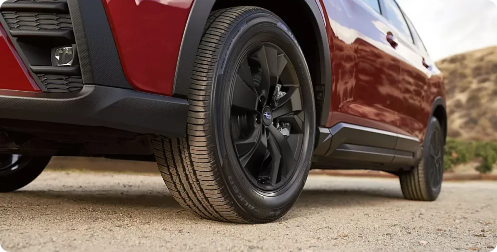 Ground clearance and wheel detail of a 2026 Subaru Ascent on a dirt shoulder