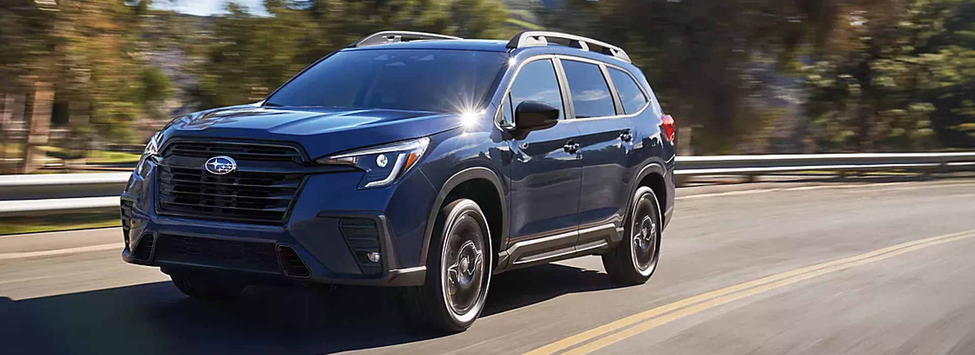 2026 Subaru Ascent three-row SUV on a tree-lined road
