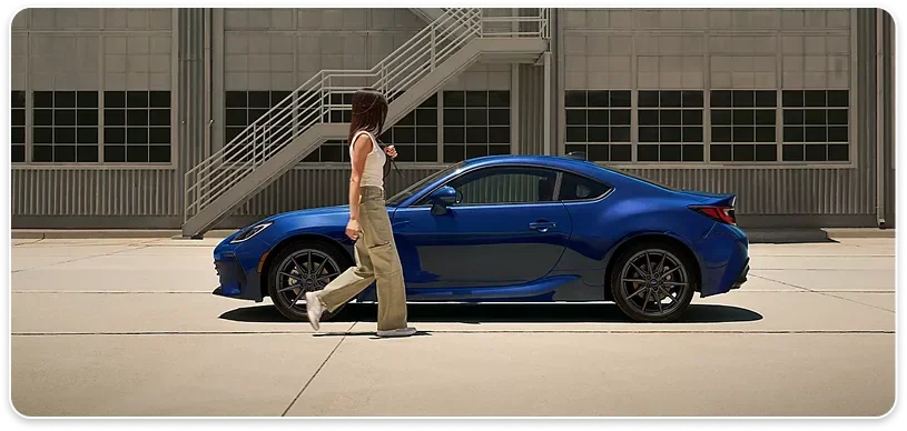 Blue 2026 Subaru BRZ in profile as its owner walks toward it