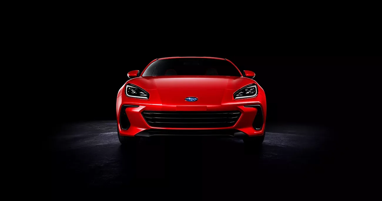 Red 2026 Subaru BRZ lit from the front against a black backdrop