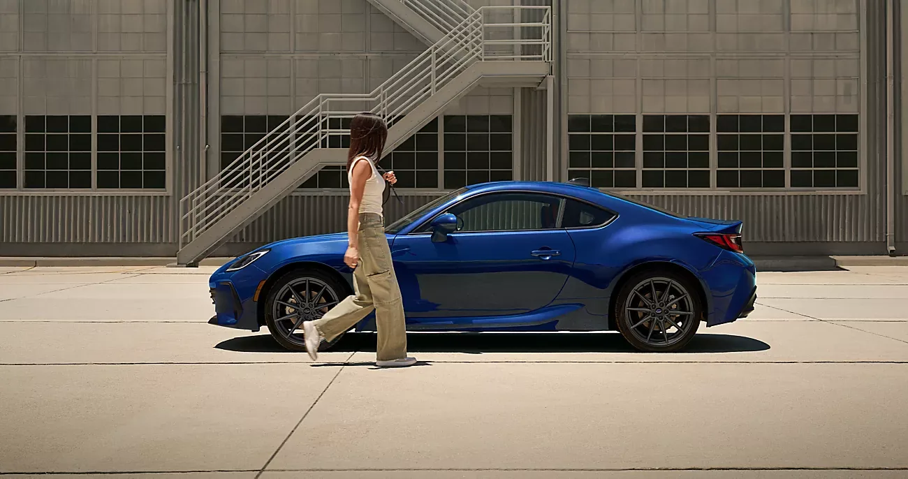 Blue 2026 Subaru BRZ in profile as its owner walks toward it