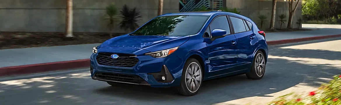 Blue Subaru hatchback on a palm-lined city street