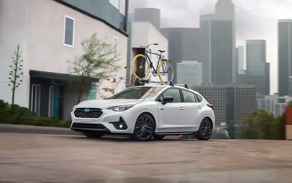 White Subaru loaded with bicycles outside a city home
