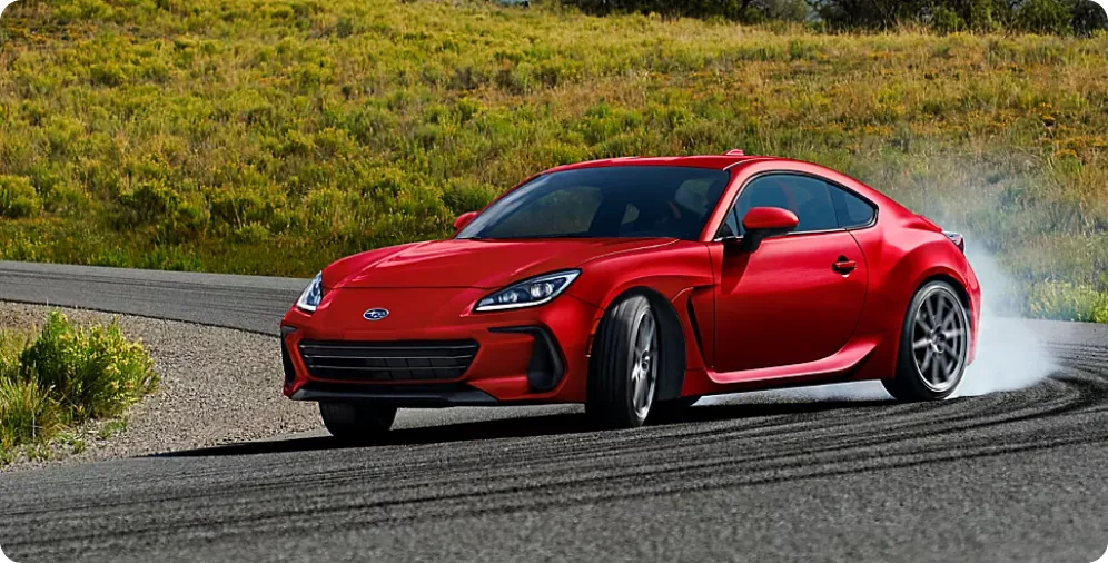 Red 2026 Subaru BRZ sliding through a corner on a hillside road