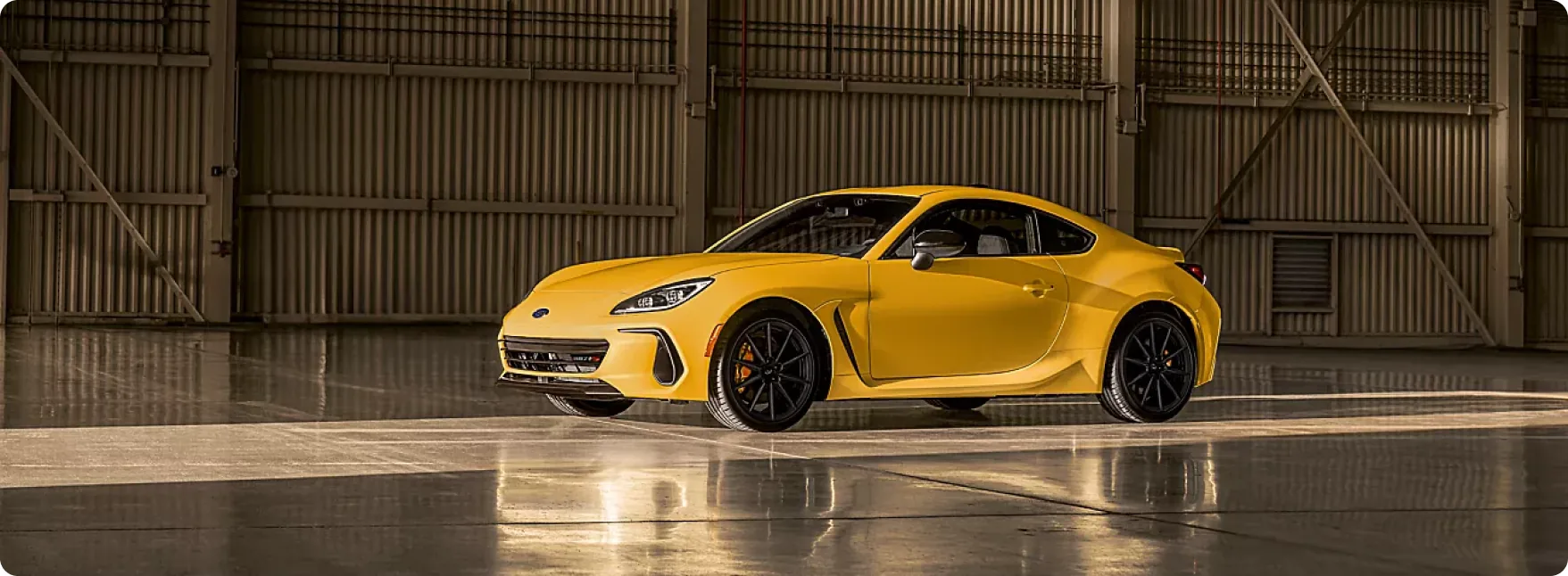 2026 Subaru BRZ Series.Yellow in Sunrise Yellow inside an industrial hangar