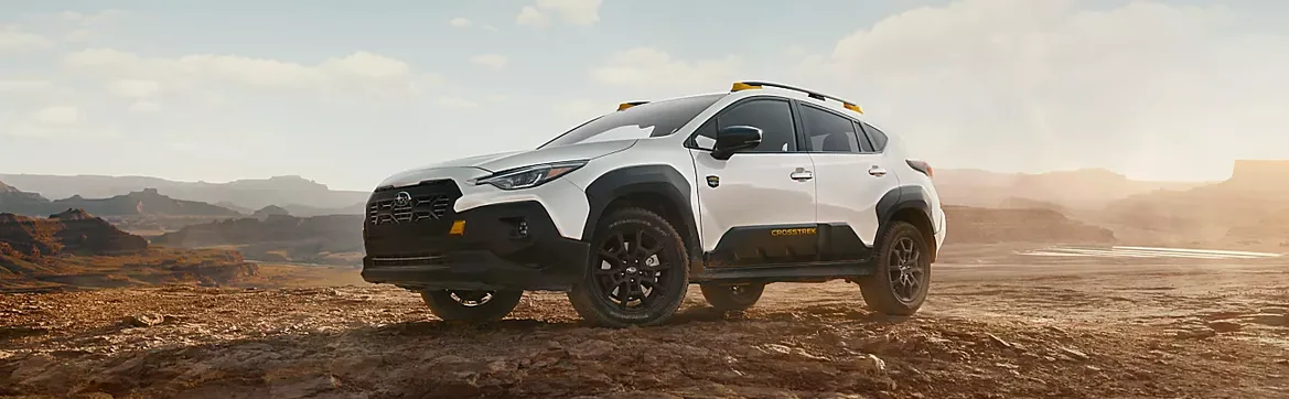 White 2026 Subaru Crosstrek Wilderness on a desert ridge at sunrise