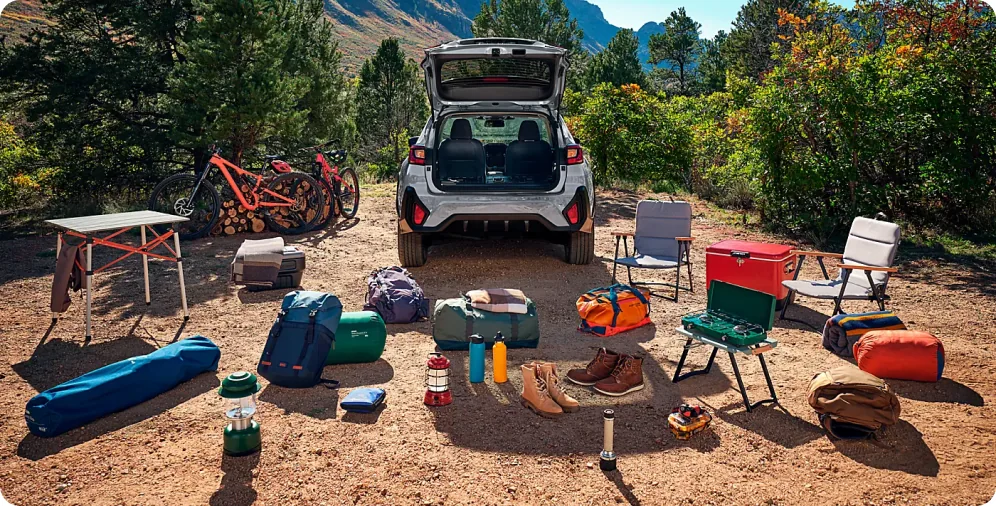 Open rear gate of a 2026 Subaru Crosstrek with camping gear laid out behind it