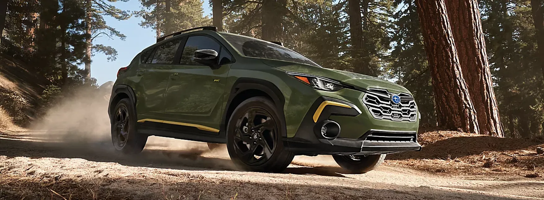 Green 2026 Subaru Crosstrek Sport kicking up dust on a forest road