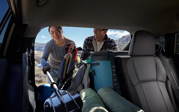 Two people loading luggage into the cargo area of the 2026 Crosstrek Hybrid