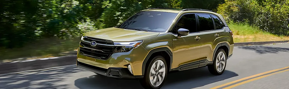 Olive green 2026 Subaru Forester Hybrid on a country road