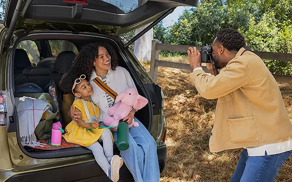 Family beside the open rear gate of a 2026 Subaru Forester Hybrid