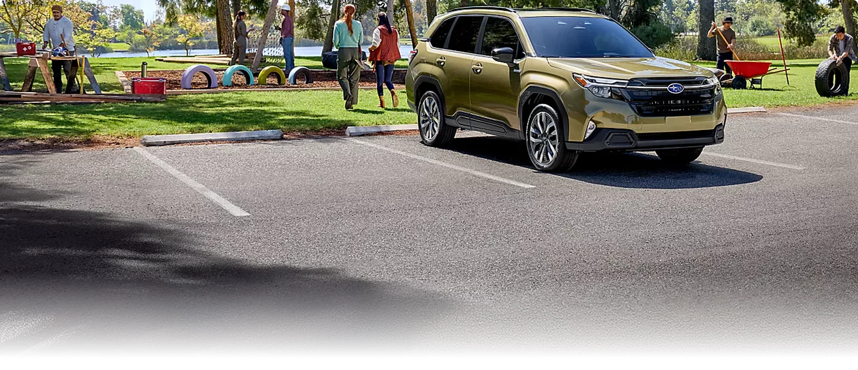 Olive green 2026 Subaru Forester Hybrid parked beside a park