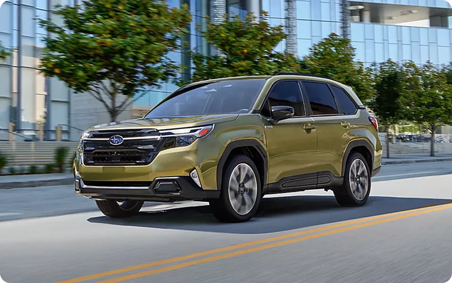 Olive green 2026 Subaru Forester Hybrid driving through the city