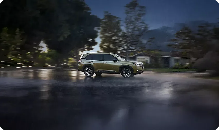 2026 Subaru Forester Hybrid driving on a wet road at dusk