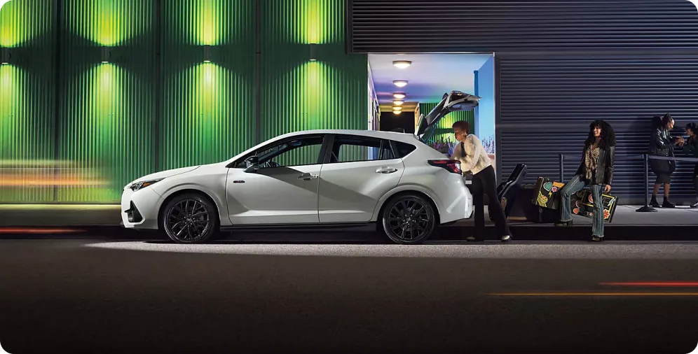 White 2026 Subaru Impreza parked outside a venue at night