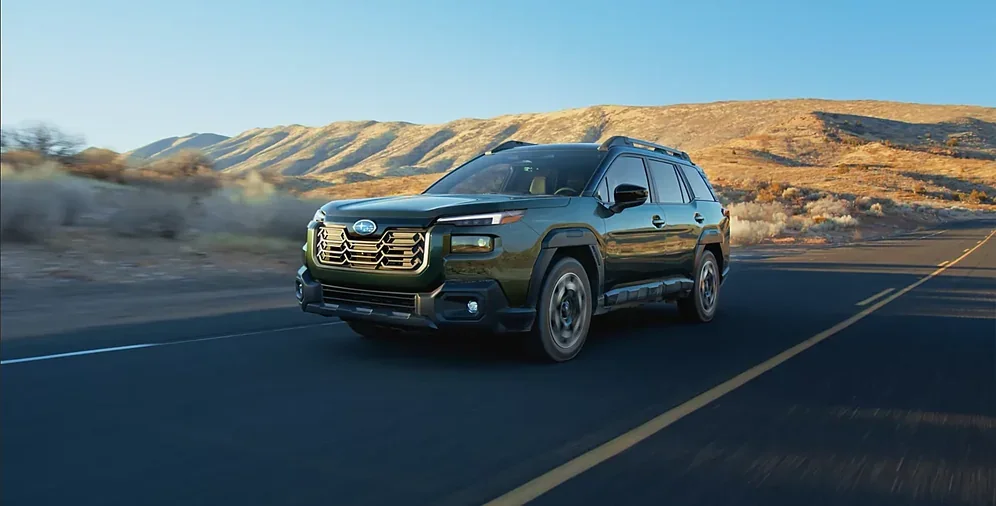Green 2026 Subaru Outback cruising a two-lane highway
