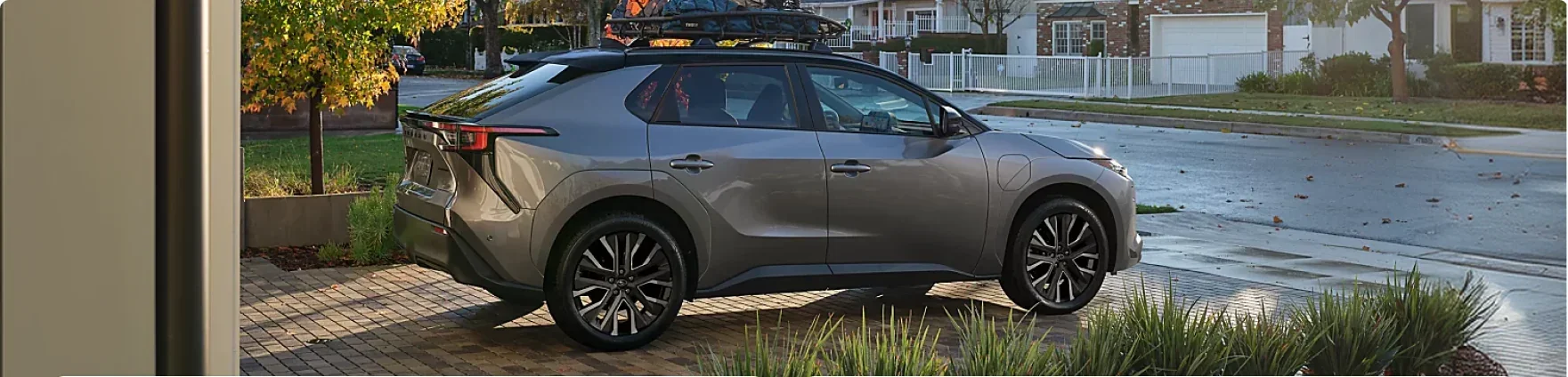 Grey 2026 Subaru Solterra with a loaded roof rack parked in a driveway