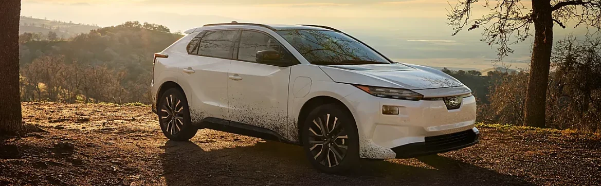 White 2026 Subaru Solterra parked on a hillside at sunrise