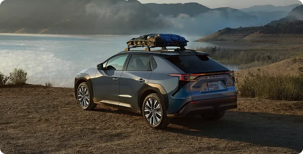 2026 Subaru Solterra loaded with roof gear on a lakeside trail