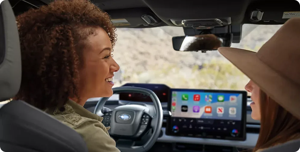 Two passengers using the voice-activated Intelligent Assistant in a 2026 Subaru Solterra