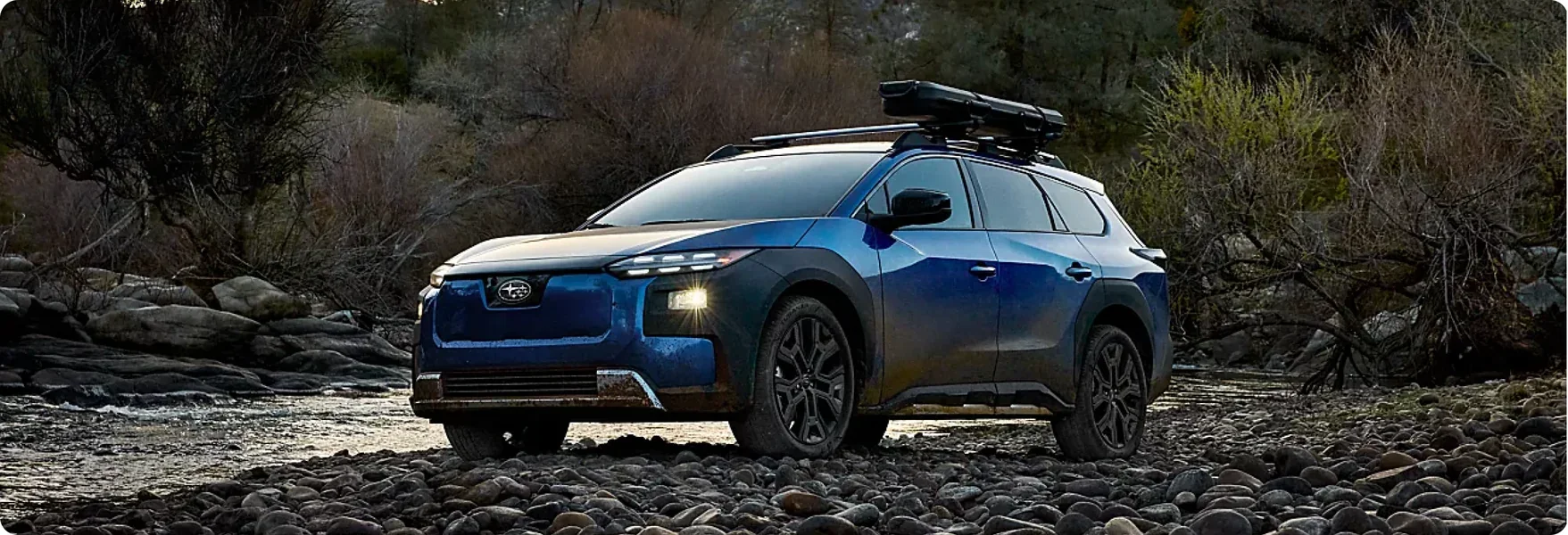 2026 Subaru Trailseeker fording a rocky creek bed with a roof box fitted