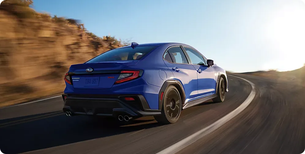 Blue 2026 Subaru WRX carving a mountain road on its track-tuned suspension