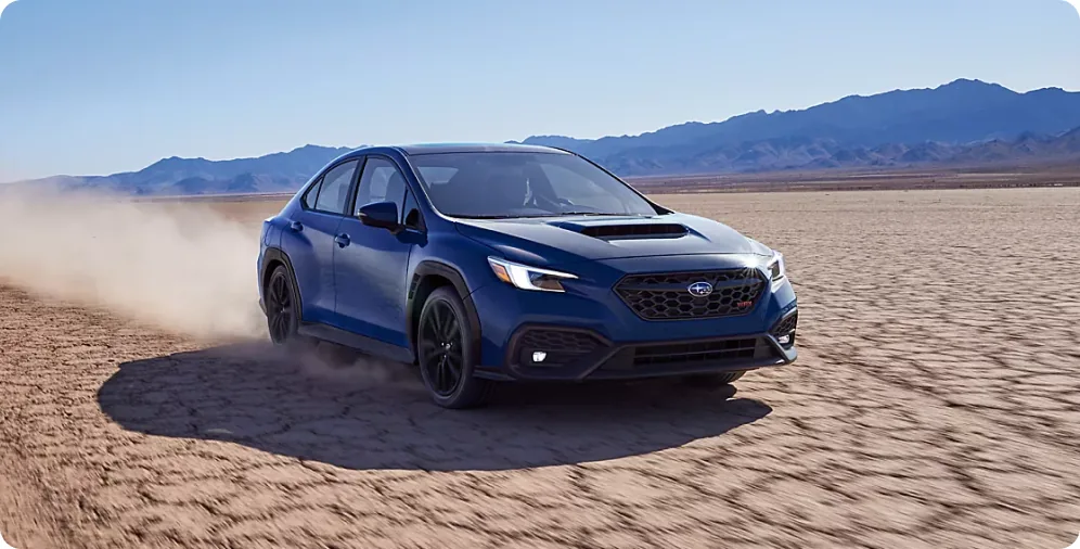 Blue 2026 Subaru WRX cornering on a dry lake bed, all four wheels gripping the loose surface