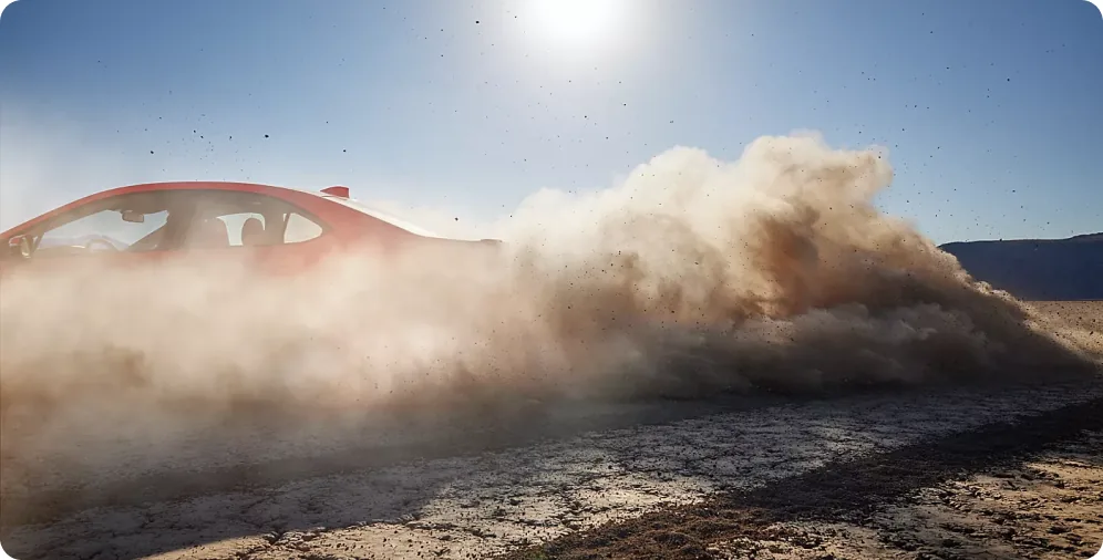 Red 2026 Subaru WRX at speed with a dust cloud thrown up behind it