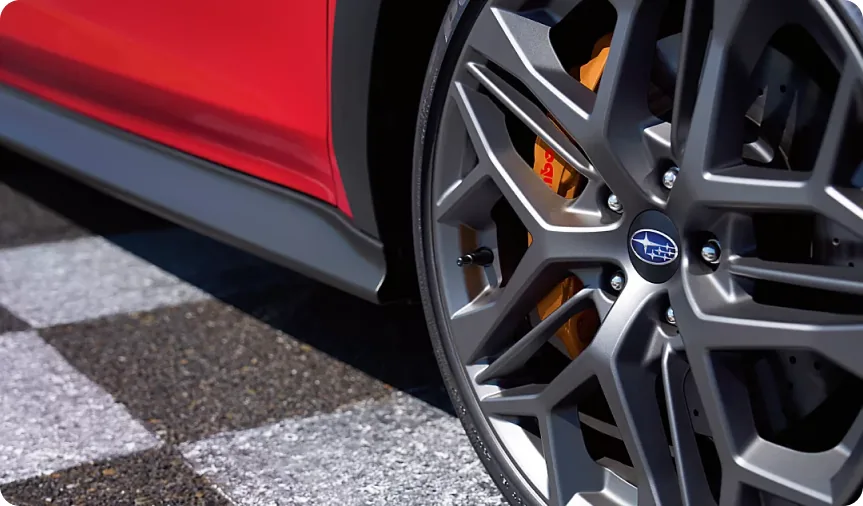 Gold-finish Brembo brake caliper behind the wheel of a red 2026 Subaru WRX tS