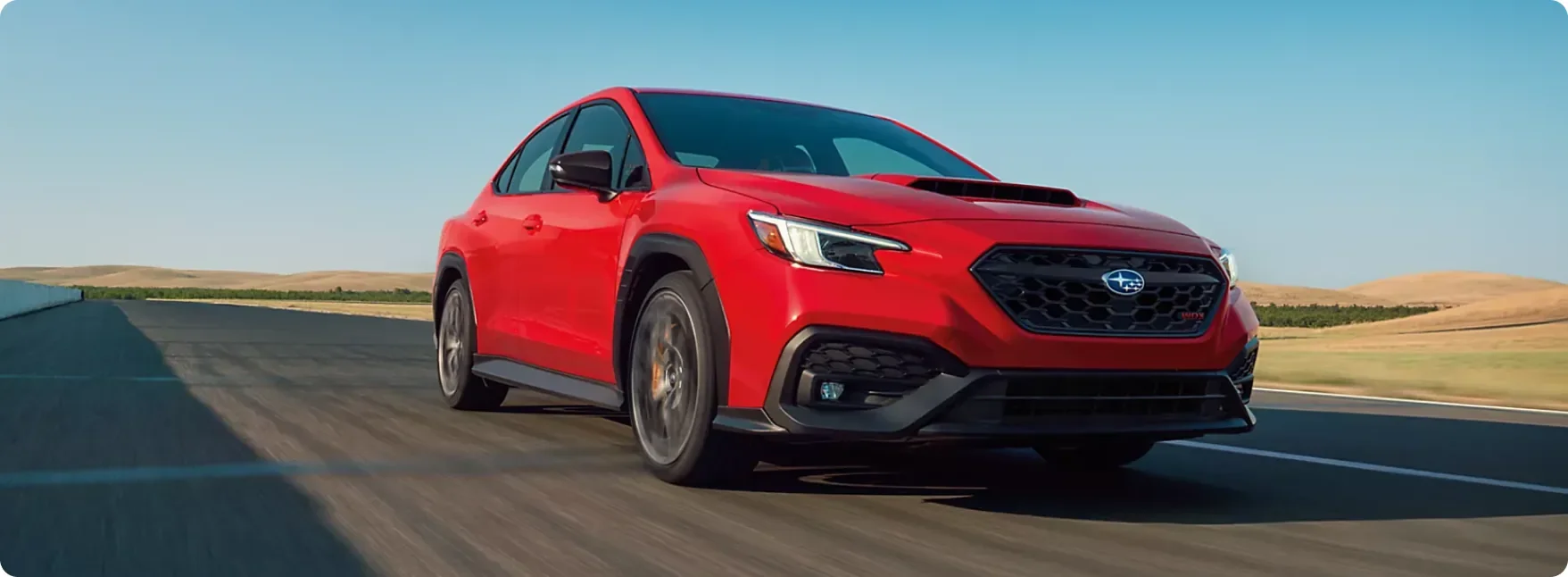 Red 2026 Subaru WRX tS at speed on an open road