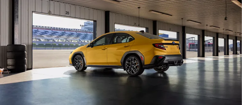 2026 Subaru WRX Series.Yellow in Sunrise Yellow parked inside a track garage