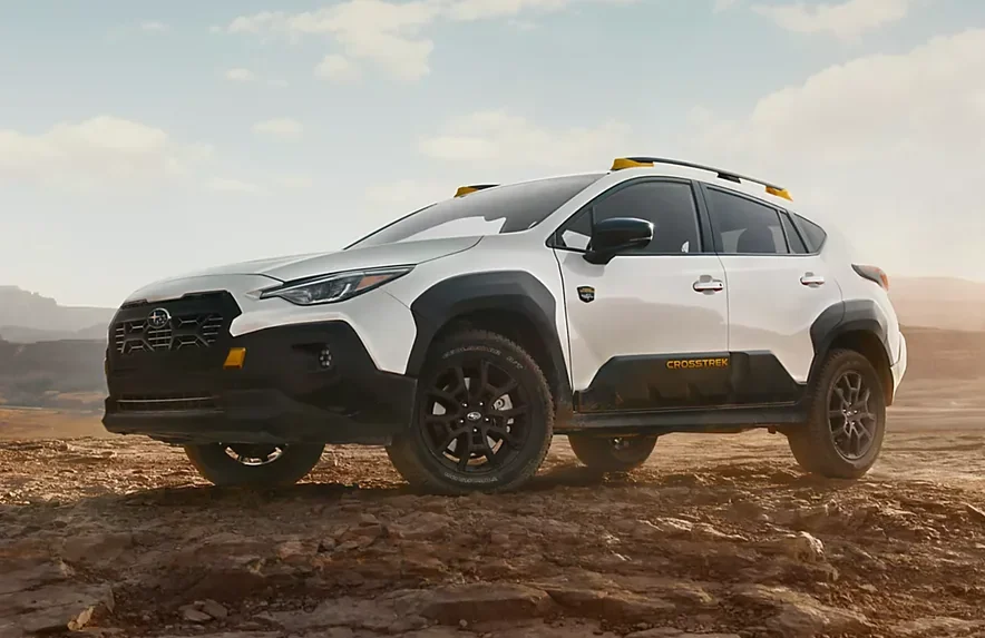 White Subaru Crosstrek Wilderness parked on a rocky desert ridge