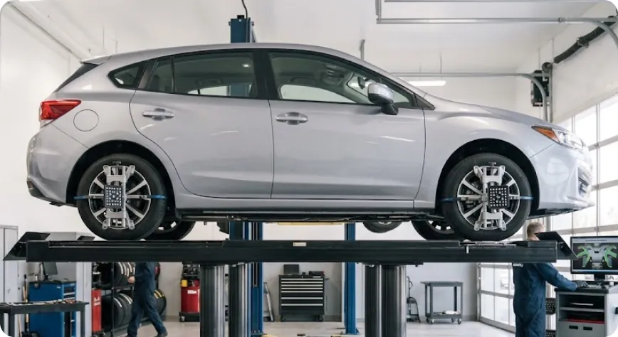 Subaru Impreza raised on the alignment rack at the Briggs Subaru of Topeka service center