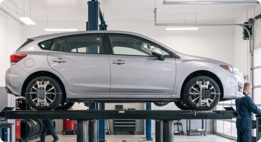 Subaru Impreza raised on the alignment rack at the Briggs Subaru of Topeka service center