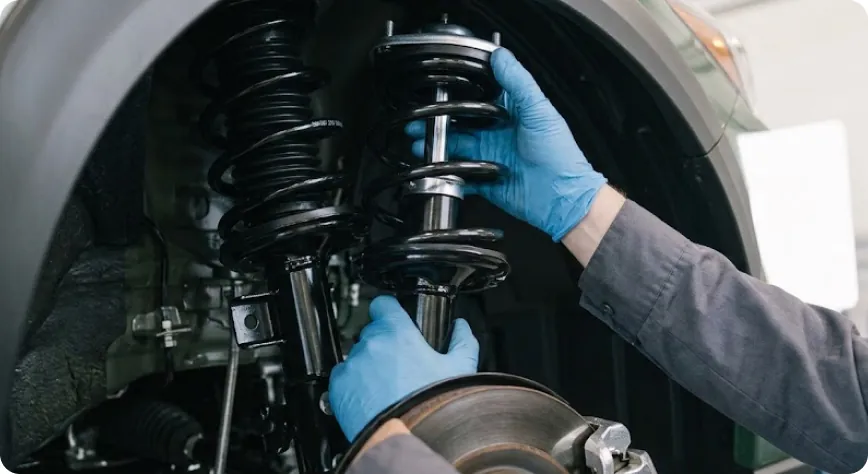 Close-up of a Briggs Subaru of Topeka technician fitting a new strut assembly to a Subaru