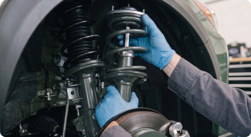 Close-up of a Briggs Subaru of Topeka technician fitting a new strut assembly to a Subaru