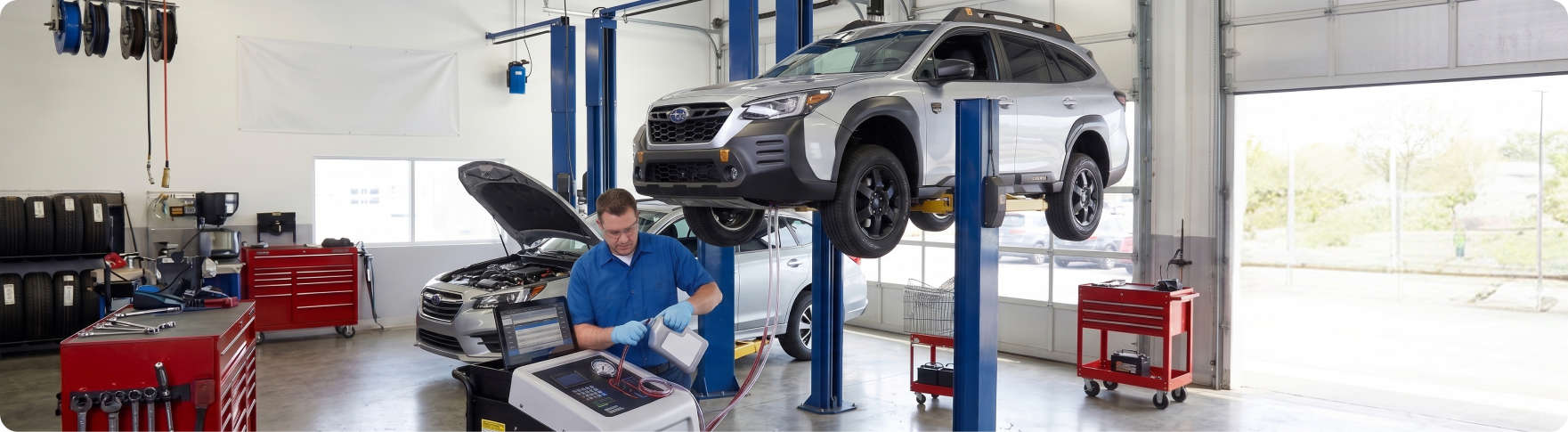 Subaru trained and certified technician adding fresh transmission fluid during a fluid exchange at Briggs Subaru of Topeka